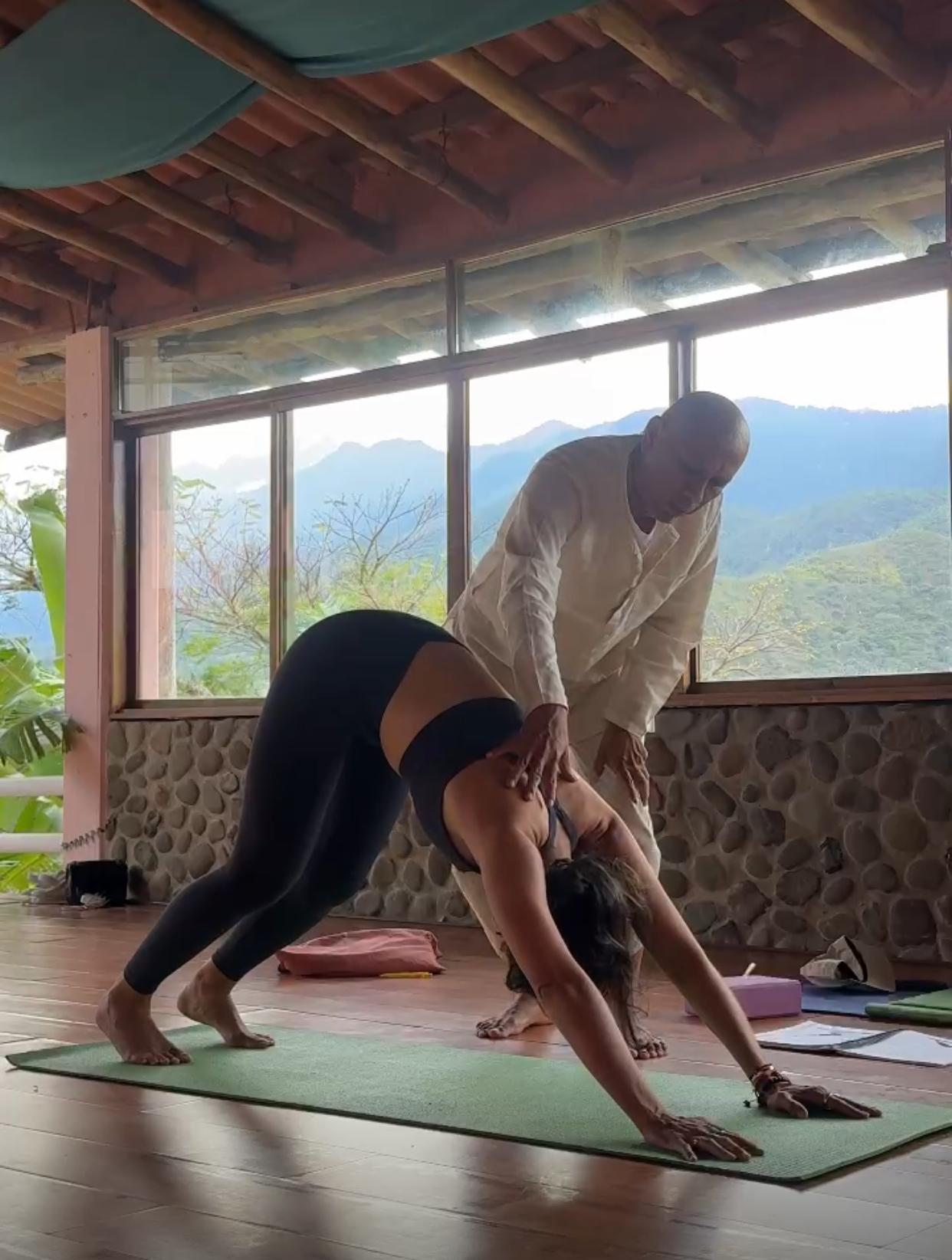 Teacher guiding a student in an asana at Yogendra Ashram