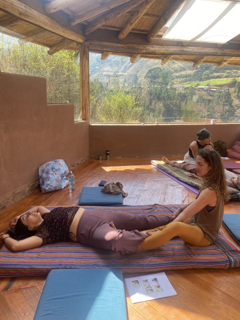 A Thai Yoga Massage student practicing leg work with a partner in Cusco