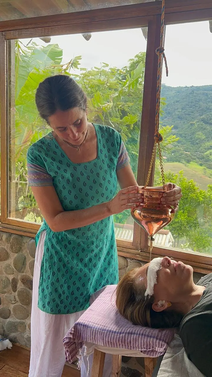 Shyam demostrando Shirodhara durante la formación en terapias ayurvédicas en Cali