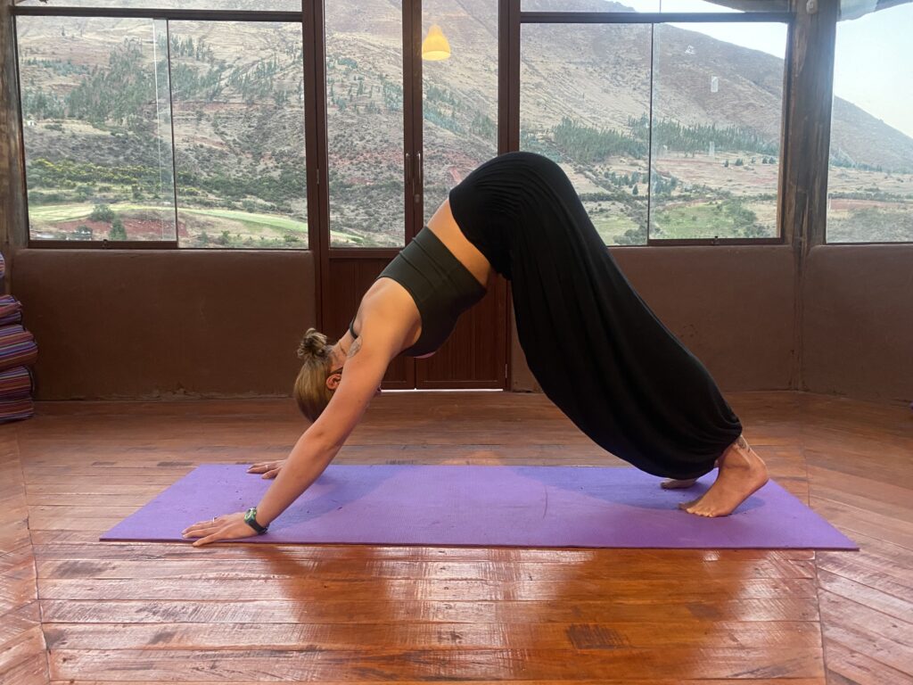 Bhakti Yoga School student practicing Downward-Facing Dog in the Cusco shala