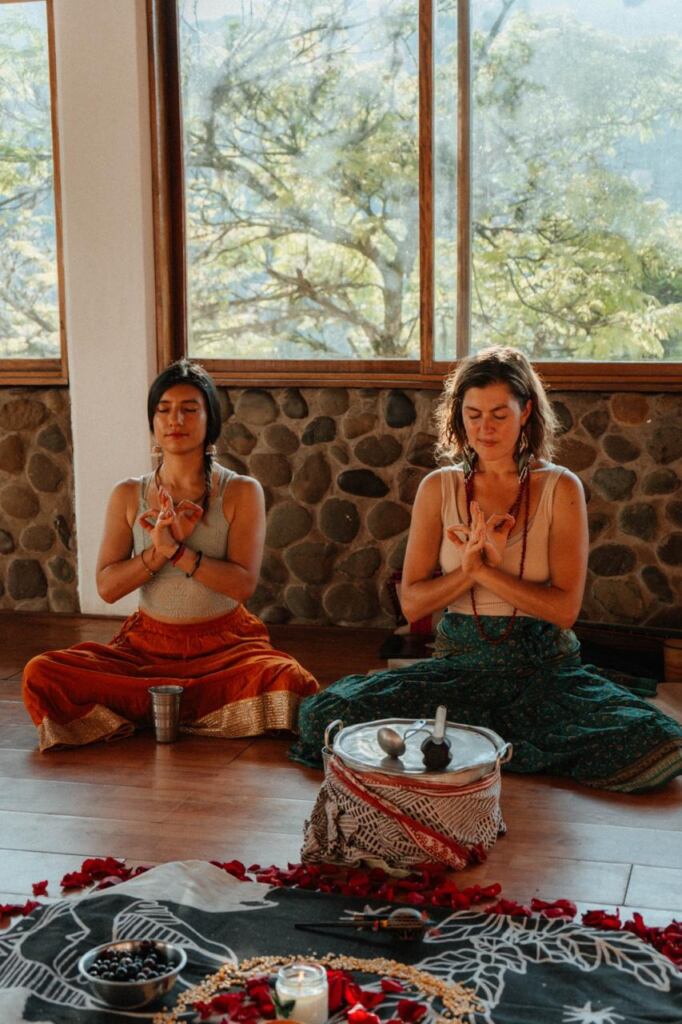 Two students meditating beside the altar in Cali