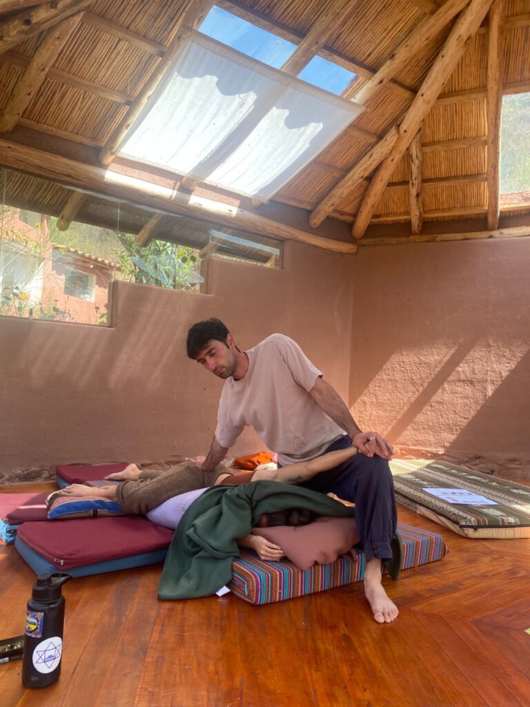 A student practicing Thai Yoga Massage leg work in the Cusco shala